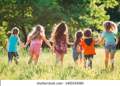 Large group of kids, friends boys and girls running in the park on sunny summer day in casual clothes  - Shutterstock ID 1405534385