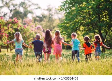 Large group of kids, friends boys and girls running in the park on sunny summer day in casual clothes  - Shutterstock ID 1405534403