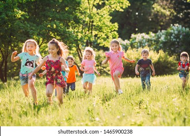 Large group of kids, friends boys and girls running in the park on sunny summer day in casual clothes  - Shutterstock ID 1465900238