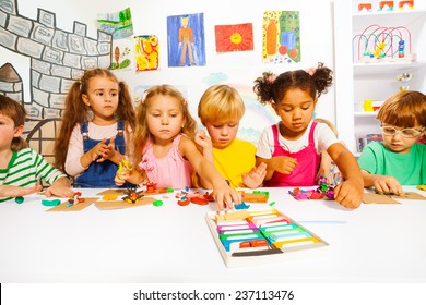 Large group of kids play with modeling clay - Shutterstock ID 237113476