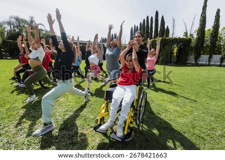 Large Group of Latin sporty multi age people stretching in training class next to mexican woman in wheelchair outdoors in a public park in Mexico Latin America. Diverse group in inclusion concept. 