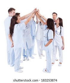 Large Group Of Motivated Doctors And Nurses Standing In A Circle Giving A High Fives Gesture With Their Hands Meeting In The Centre  Conceptual Of Teamwork Isolated On White