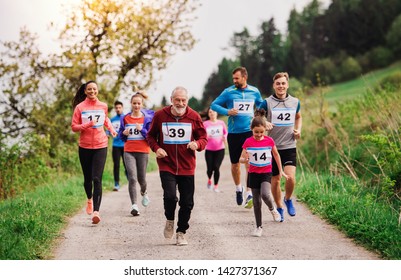 Large Group Of Multi Generation People Running A Race Competition In Nature.