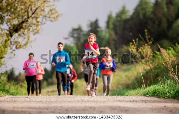 Large group of multi generation people running a\
race competition in\
nature.