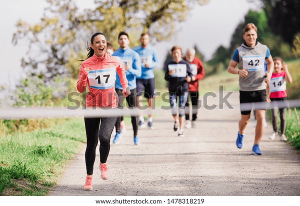 Large group of multi generation people running a
race competition in
nature.