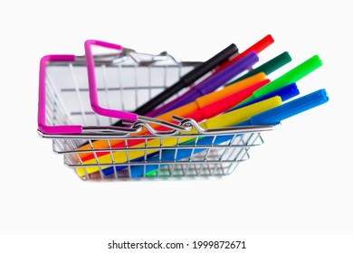 A Large Group Of Multicolored Markers In A Miniature Shopping Basket In A Supermarket, Isolated On A White Background, Close-up. The Cart. Return To School.