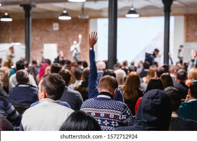 Large group of people at the Conference Watching Presentation and listening to speaker. Business people concept and Ideas, education. Speaker interacting to listener from auditorium, raising hang. - Powered by Shutterstock