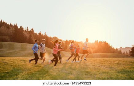 Large Group Of People Cross Country Running In Nature.