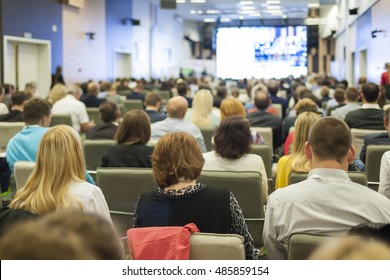 Large Group Of People On A Conference. Watching Business Presentation On A Big Screen In Front. Horizontal Image