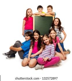 Large Group Of School Kids, Boys And Girls Sitting By The Blackboard, Isolated On White