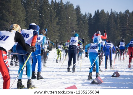 Large group of skiers on ski slopes in a mountain resort in winter