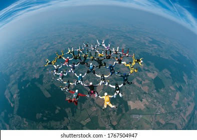 Large Group Of Skydivers Flying In Formation Over Earth Elevated View