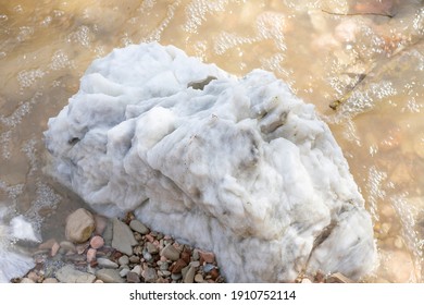 Large Gypsum Rock Or Stone Surrounded By Water. Big Wet Calcite Washed In The River Shore With Lots Of Waves. Semi Precious White Gem Deposit Or Mining