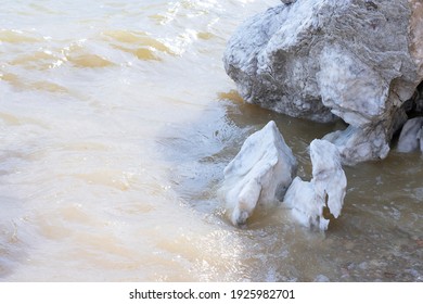 Large Gypsum Rock Or Stone Surrounded By Water. Big Wet Calcite Washed In The River Shore With Lots Of Waves. Semi Precious White Gem Deposit Or Mining