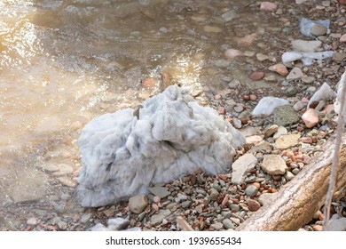 Large Gypsum Rock Or Stone Surrounded By Water. Big Wet Calcite Washed In The River Shore With Lots Of Waves. Semi Precious White Gem Deposit Or Mining