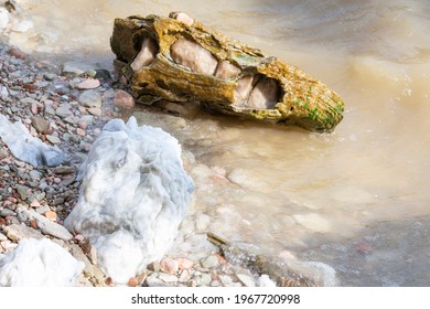 Large Gypsum Rock Or Stone Surrounded By Water. Big Wet Calcite Washed In The River Shore With Lots Of Waves. Semi Precious White Gem Deposit Or Mining