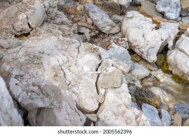 Large Gypsum Rock Or Stone Surrounded By Water. Big Wet Calcite Washed In The River Shore With Lots Of Waves. Semi Precious White Gem Deposit Or Mining