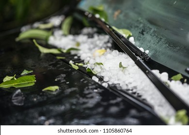 Large hail ice balls on car hood after heavy summer storm