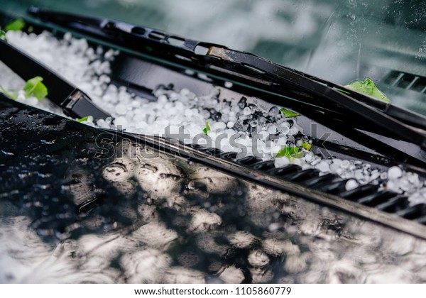 Large\
hail ice balls on car hood after heavy summer\
storm