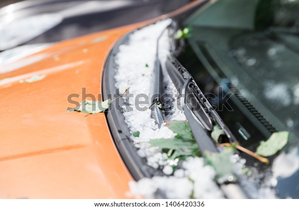 Large\
hail ice balls on car hood after heavy summer\
storm