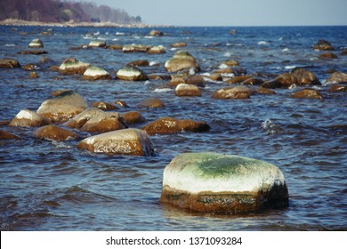 Large half-white stones in the sea with remains white sea salt 