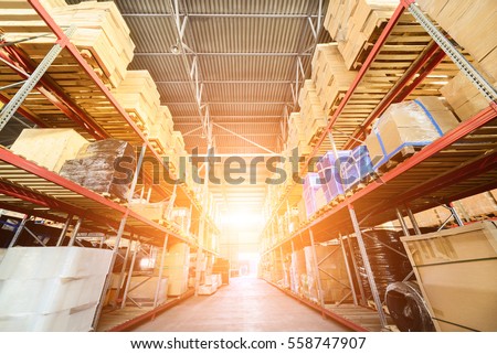 Large hangar warehouse industrial and logistics companies. Warehousing on the floor and called the high shelves. Bright sunlight.