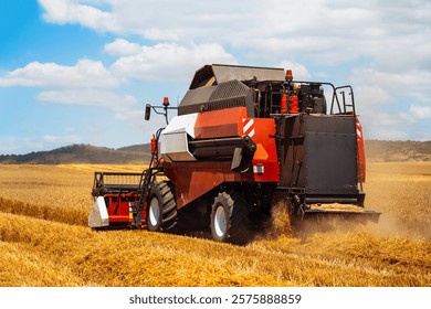 A large harvesting machine operates in a sprawling field, collecting ripe crops under a bright sky.