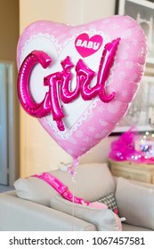 Large heart-shaped balloon with pink baby girl letters. Baby shower party decoration. 