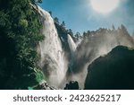 Large Hesjedalsfossen waterfall next to the road in Hordaland, Norway. Long exposure of flowing water. Water cascading down the stones in the forest. Fairy-tale and mysterious atmosphere, no people.