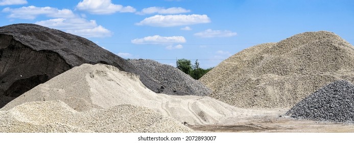 Large hills and piles of sand, gravel, crushed stone of white, gray and black color.                        - Shutterstock ID 2072893007