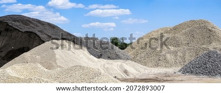 Large hills and piles of sand, gravel, crushed stone of white, gray and black color.                       