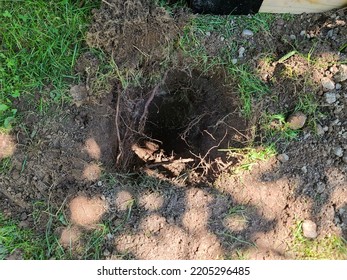 A Large Hole In The Ground Dug So A Fence Post Can Be Installed.