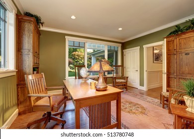 Large Home Office Interior With Green Olive Walls. Furnished With Two Bookcases, Desk And Two Chairs By The Window. Northwest, USA