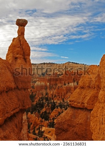 A large Hoodoo on the edge of Bryce Canyon in Utah, with the Multi-colored Hoodoo filled Amphitheatre in the background.