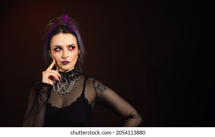 Large horizontal image Woman with halloween makeup on dark colored hair background looking to the side, goth feel, space for copy-3.tif