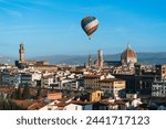 A large hot air balloon over the center of Florence. View of the renaissance capital from Piazza Michelangelo. Santa Maria del Fiore.