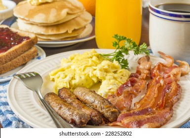 Large Hot Breakfast With Scrambled Eggs And Bacon Sausage Served With Pancakes And Toast 