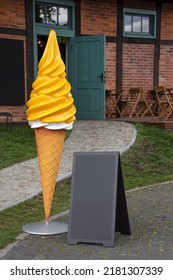 Large Ice Cream Plastic Figure Near The Ice Cream Cafe In The Park. Blank Restaurant Shop Sign Or Menu Board. Cafe Menu On The Street. Blackboard Sign Mockup In Front Of A Restaurant