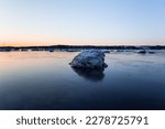 Large iceberg on the St. Lawrence river, with other chunks and the south shore in the background seen during a late winter sunrise, Cap-Rouge area, Quebec City, Quebec, Canada 