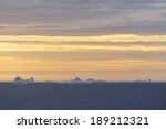 Large icebergs on the horizon floating in the Davis Straights, Greenland. Taken around midnight the image shows the effect of the midnight sun in the arctic.