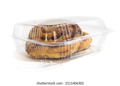 Large Iced Cinnamon Buns, Or Danish Butter Horns, In A Clear Plastic Clam Shell Or Blister Pack Isolated On White