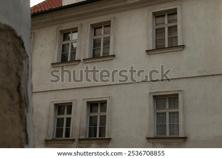 A large and impressive building featuring numerous windows along its walls, topped with a striking redcolored roof