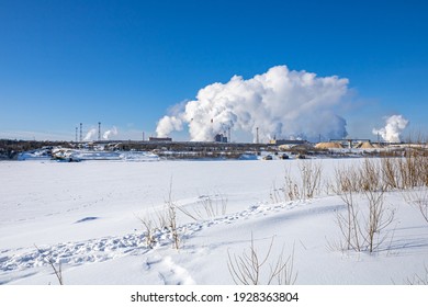 A Large Industrial Complex Against The Backdrop Of A Bright Blue Sky.