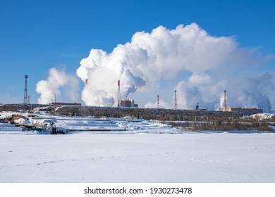 A Large Industrial Complex Against The Backdrop Of A Bright Blue Sky.