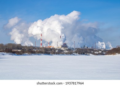 A Large Industrial Complex Against The Backdrop Of A Bright Blue Sky.