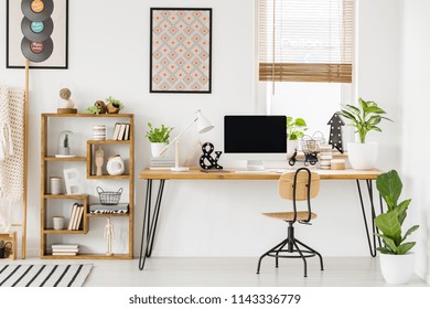 Large Industrial Desk With A Computer By A Window, A Wooden Bookcase And Posters On A White Wall In A Stylish, Scandi Home Office Interior