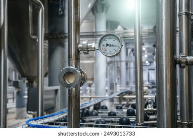 Large industrial stainless steel pipes and pressure gauge in modern brewery. - Powered by Shutterstock