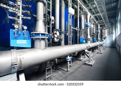 Large industrial water treatment and boiler room. Shiny steel metal pipes and blue pupms and valves.  Industry, technology, special equipment, pure drinking water, biotechnology, chemistry, ecology