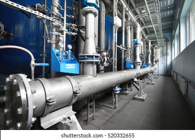 Large Industrial Water Treatment And Boiler Room. Shiny Steel Metal Pipes And Blue Pupms And Valves.