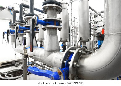 Large Industrial Water Treatment And Boiler Room. Shiny Steel Metal Pipes And Blue Pupms And Valves.